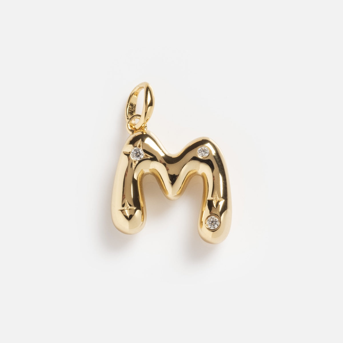The Star Crossed Celestial Bubble Letter Charm is a gold pendant shaped like the letter M, featuring four small diamonds on the front and displayed against a plain white background.