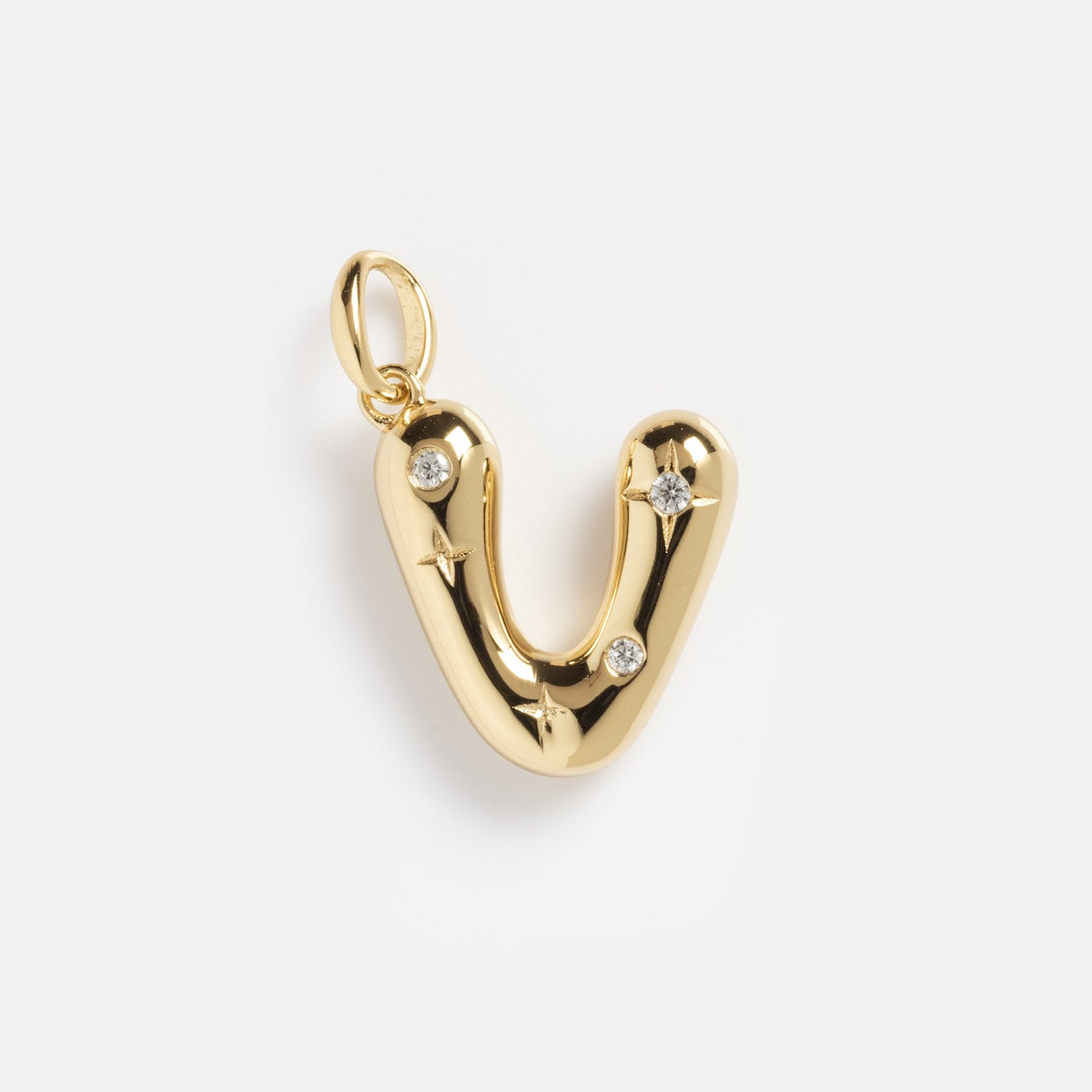 The Star Crossed Celestial Bubble Letter Charm features a gold letter V with a smooth, shiny finish, accented by three clear gemstones and star-shaped engravings on a plain white background.
