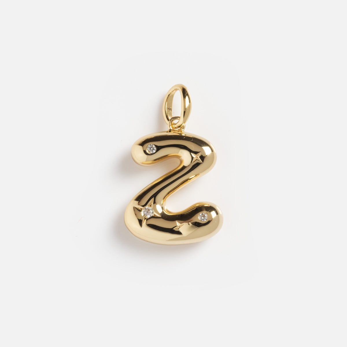 The Star Crossed Celestial Bubble Letter Charm is a shiny gold Z-shaped pendant with three small embedded gemstones and a top loop for chains, shown on a plain white background.