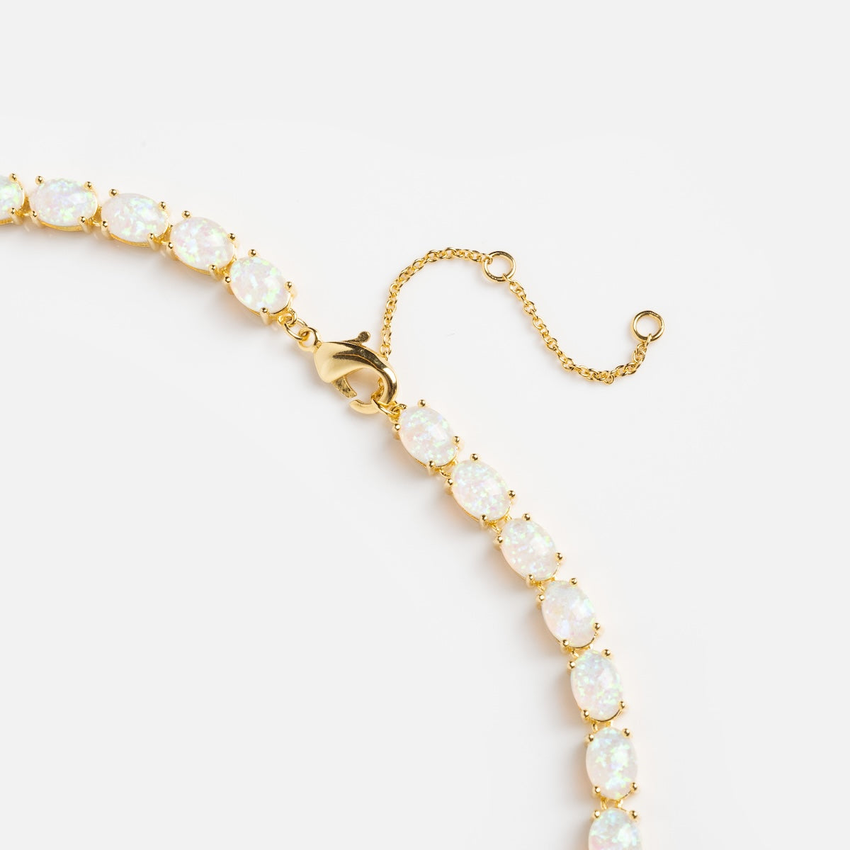 The Baby Blue Opal Eternal Tennis Necklace, featuring oval opal gemstones and an adjustable clasp, is displayed against a plain white background.