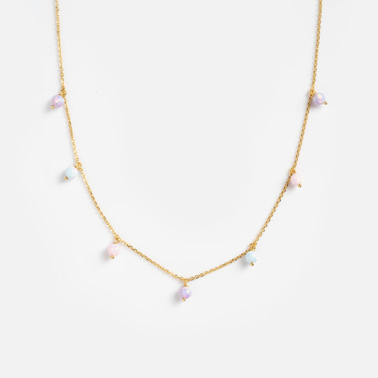 The Cotton Candy Opal Droplet Necklace features a delicate gold chain adorned with small pastel opal beads, evenly spaced and beautifully displayed against a plain white background.