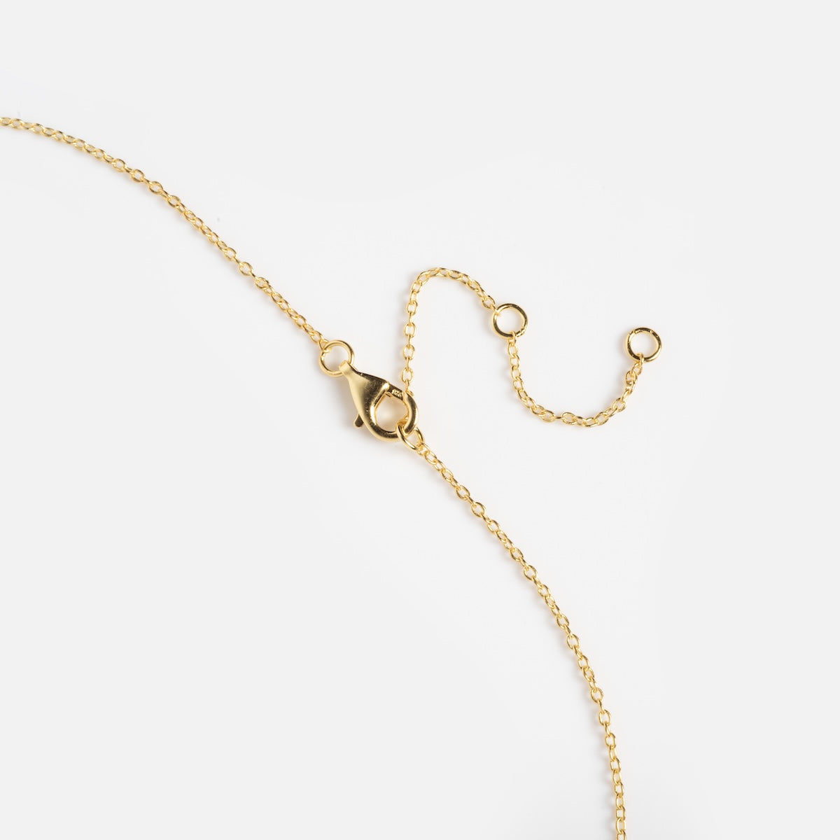 A Pink Opal Crescent Moon Pendant hangs from a delicate gold chain with a lobster clasp and adjustable loops, displayed on a plain white background.