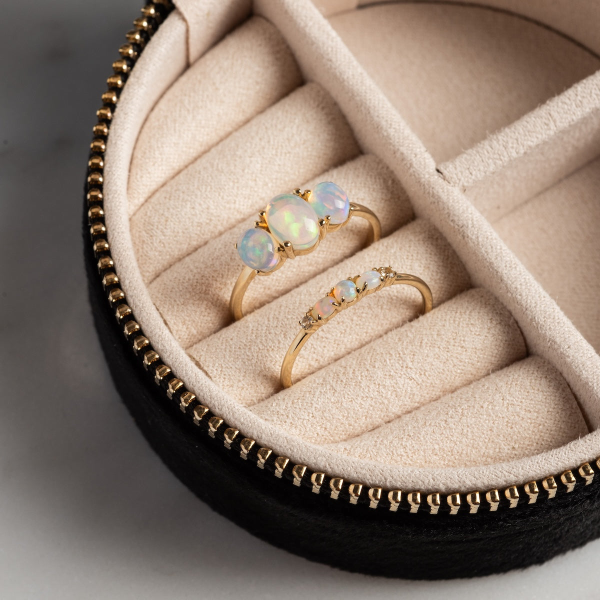 The Solid Gold 2025 October Capsule Opal Ring Set features two opal rings in a cream velvet-lined holder with a black zipper case, plus a free gift.