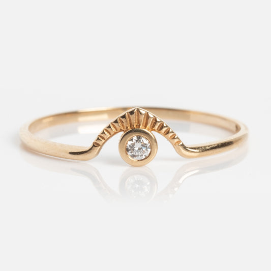 The Corrie Ring is a delicate gold band with a textured wave design, highlighted by a single round diamond set in the center beneath its elegant raised curve.