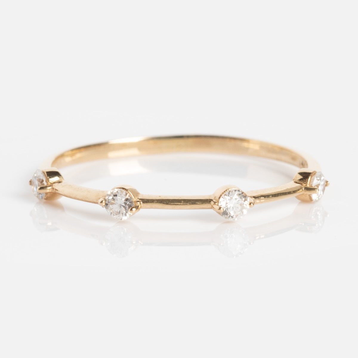The Munro Ring is a thin gold band with five evenly spaced round diamonds, shown on a white background.