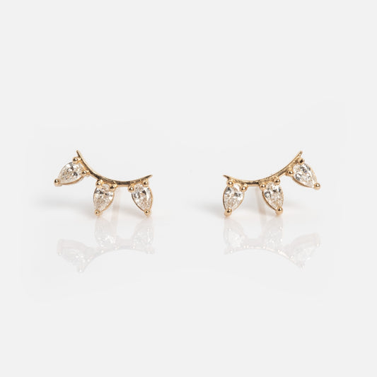 Rain Diamond Studs: Elegant gold earrings featuring three dangling teardrop-shaped clear gemstones in a curved design, displayed against a white background.