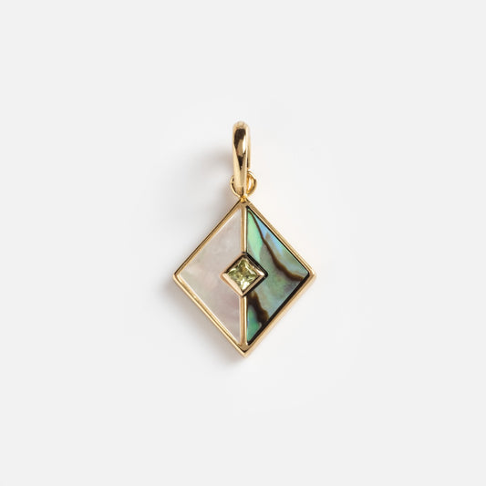 The Charms by Carrie Elizabeth Jewelry pendant features a diamond-shaped gold frame, sections of iridescent abalone shell and white mother-of-pearl divided by gold lines, and a small central green gemstone.