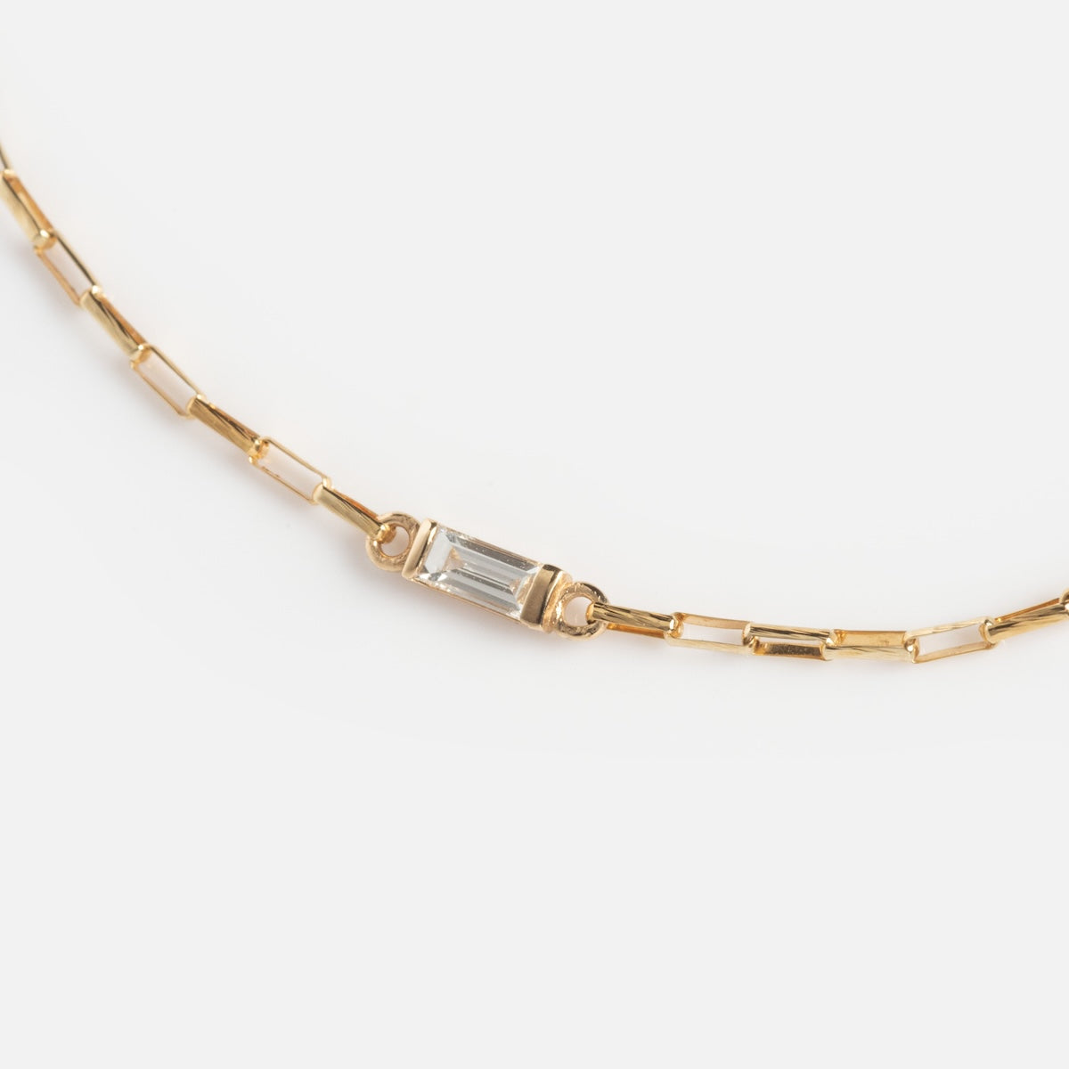 The Sunblink Diamond Bracelet features rectangular links and a clear, horizontally set diamond centerpiece in gold, shown on a white background.