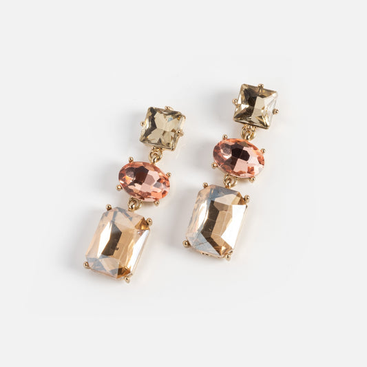 The Bold Drop Earrings Sample features a gold-tone dangle design with three faceted gemstones: square champagne, oval pink, and large rectangular light gold, all set against a white background.
