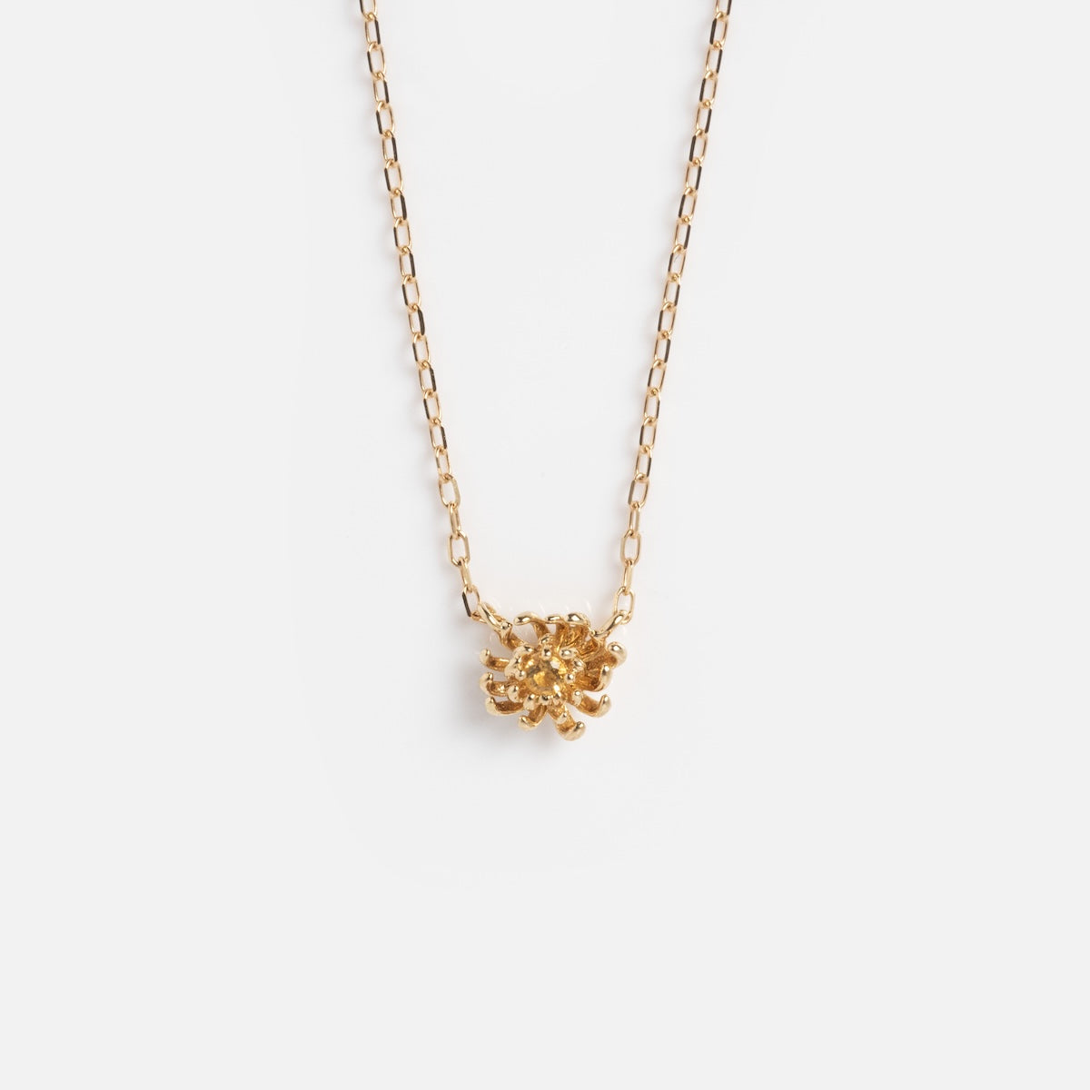 The Solid Gold Birth Flower Bloom Necklace is a delicate gold chain with a small birth flower pendant, shown against a plain white background.