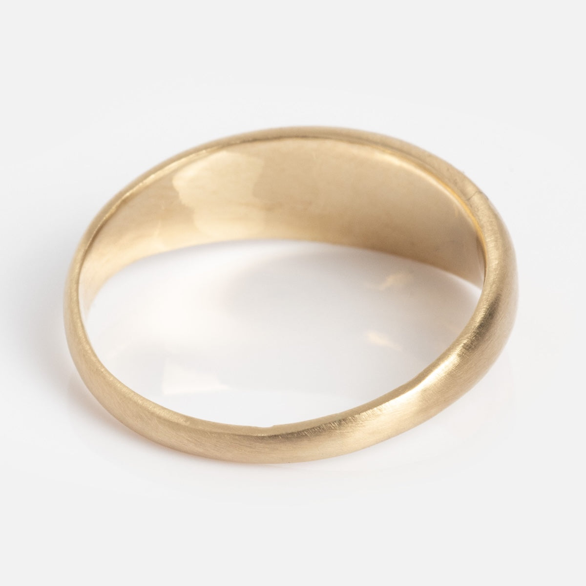 The Half Moon Bombe Ring features a simple, polished gold design with a smooth finish, photographed on a white background.