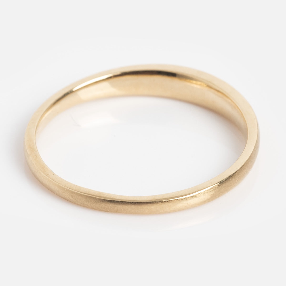 The Soulmate Band is a simple, polished gold ring with a smooth, rounded band, displayed on a plain white background.