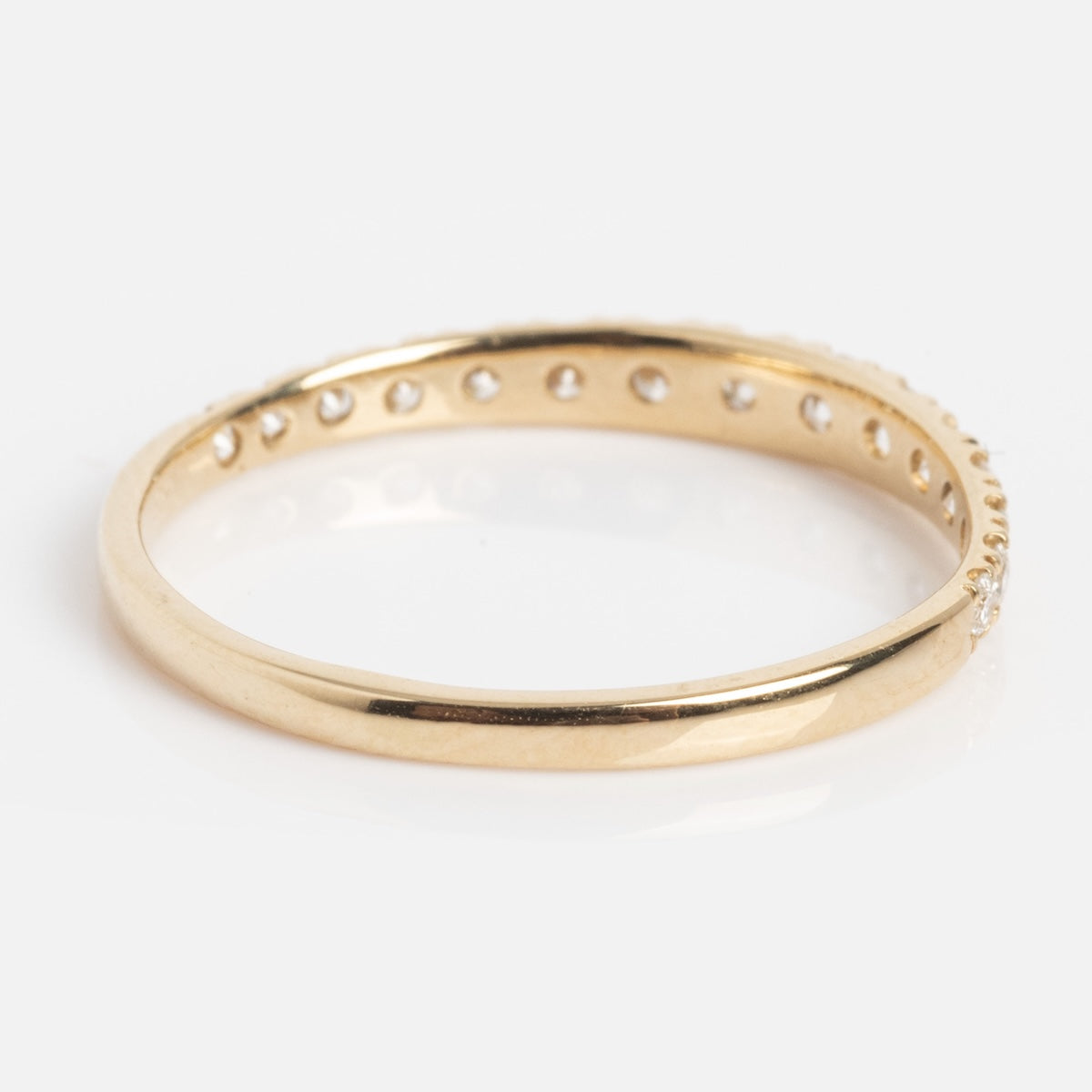 The Echo Diamond Band is a thin gold ring featuring small round holes evenly spaced along one side, shown on a white background.