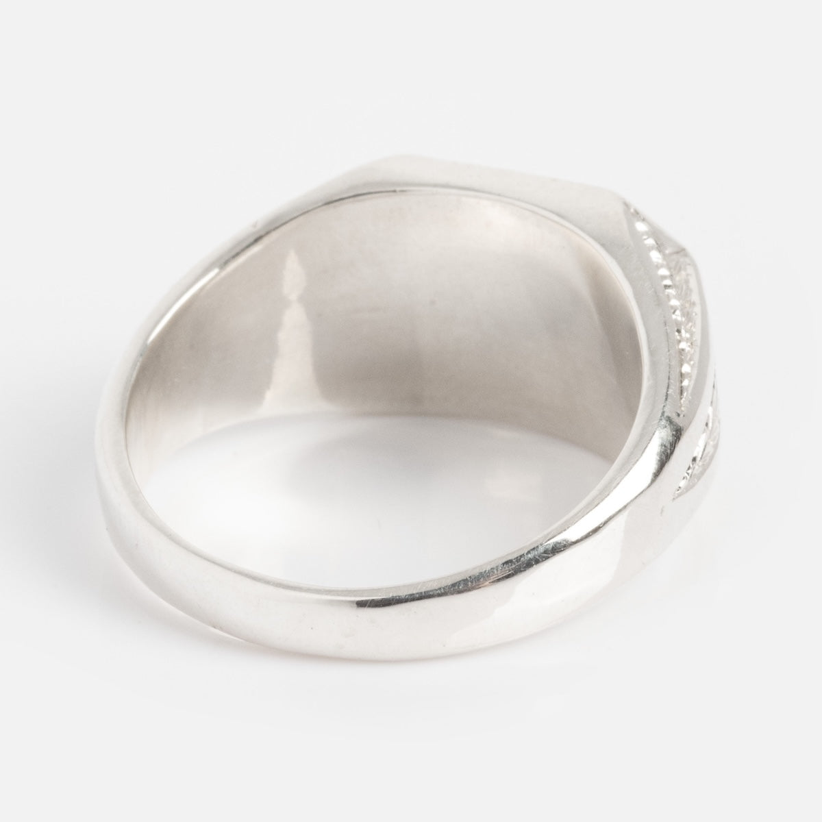 A close-up of the Sovereign Signet Ring, featuring a smooth, polished silver finish and a slightly thick band, displayed against a plain white background.