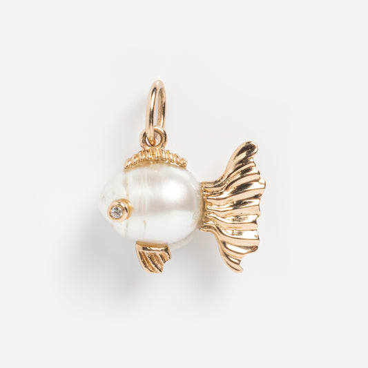 The Solid Gold Nature Charm is a fish-shaped pendant with gold-toned fins and tail, a white pearl body, and a small gemstone for the eye, displayed against a plain white background.