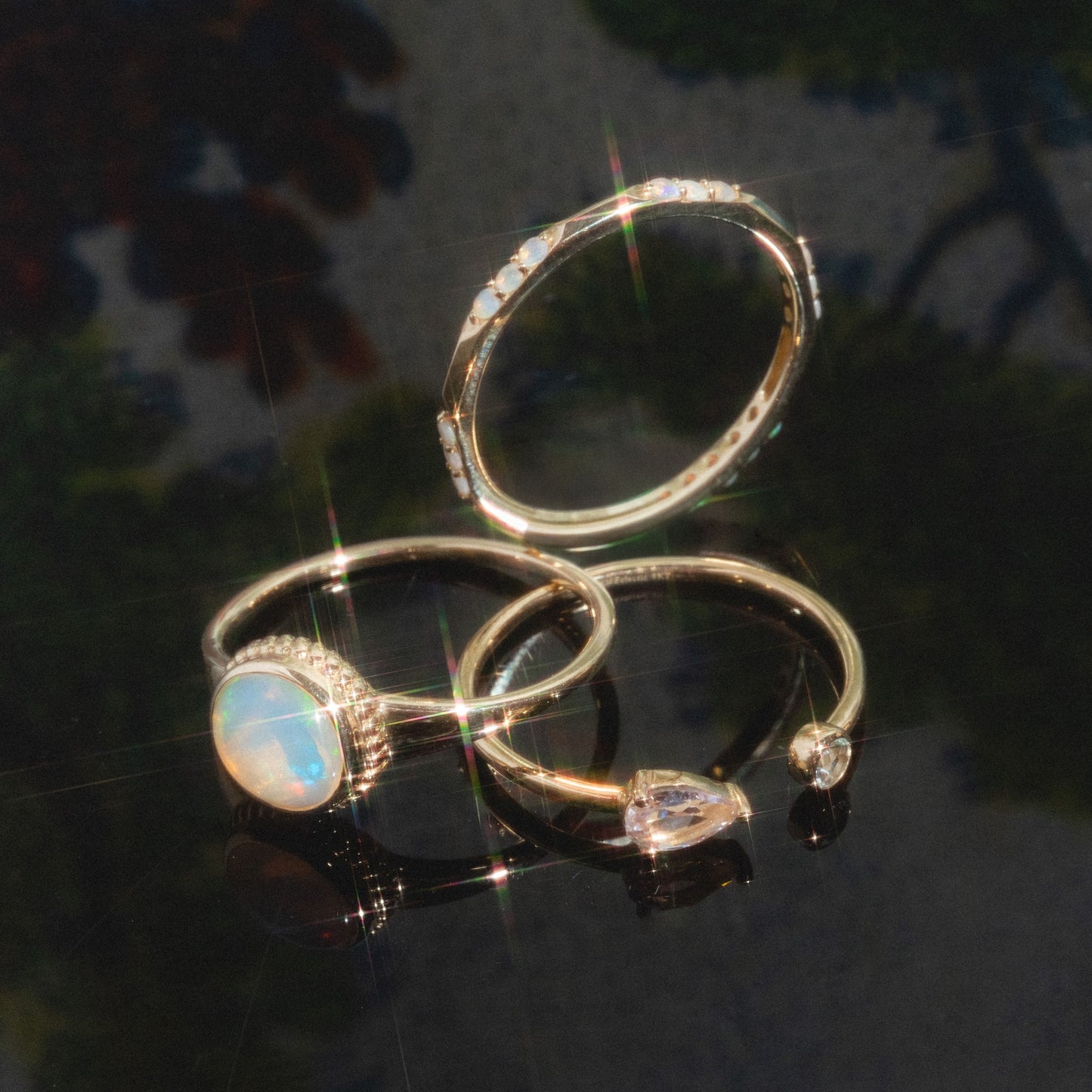 The Solid Gold Textured Opal Signet Ring features a delicate gold band set with an opal gemstone, reflecting colorful light.