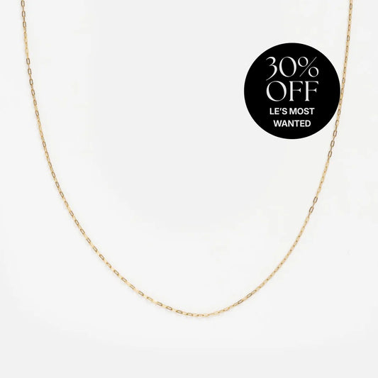 A Solid Gold Delicate Paperclip Chain necklace is shown on a white background with a black circular label stating "30% OFF LES MOST WANTED" in white text.