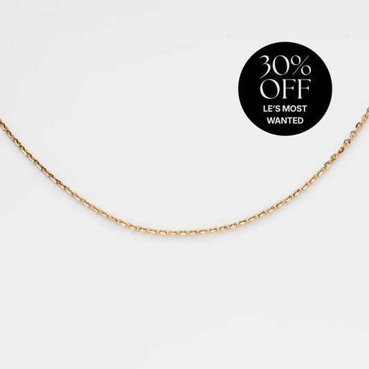 The Solid Gold Simple Glimmer Gold Chain is shown on a white background, featuring a black circular label in the corner that says 30% OFF LES MOST WANTED.