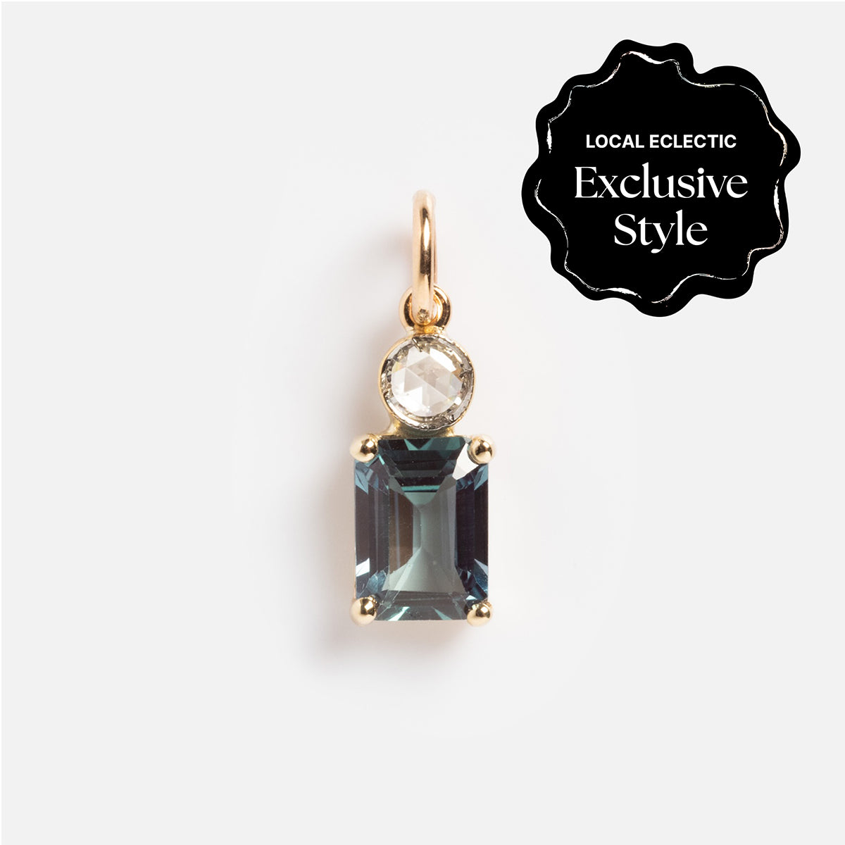 A gold pendant featuring a round diamond above a larger rectangular lab alexandrite, with a small loop at the top. A black corner label reads “Local Eclectic Exclusive Style.” Product: One of a Kind 14k Lab Alexandrite and Diamond Charm.