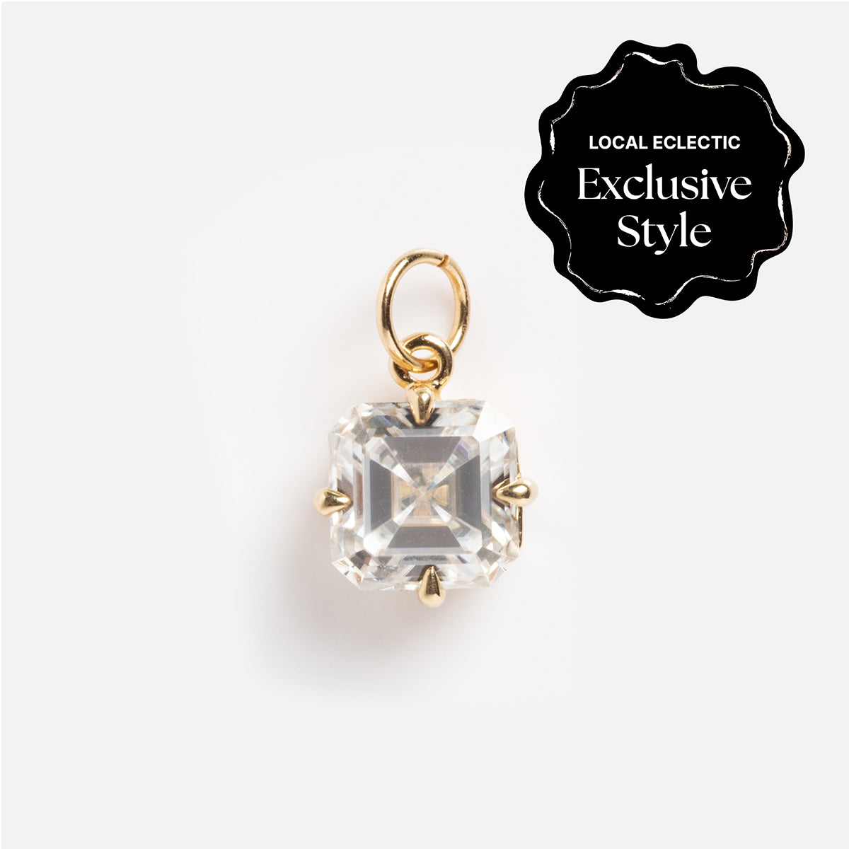 A 14k gold oval moissanite charm with hand-engraved details and a top loop for a necklace. Labeled as a Local Eclectic Exclusive Style: One of a Kind 14k Oval Moissanite Charm with Hand Engraved Details.