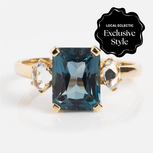 The One of a Kind 14k Vintage Inspired London Blue Topaz and White Sapphire Ring features a large rectangular blue topaz center stone, two smaller white sapphires, and a Local Eclectic Exclusive Style badge in the top right corner.