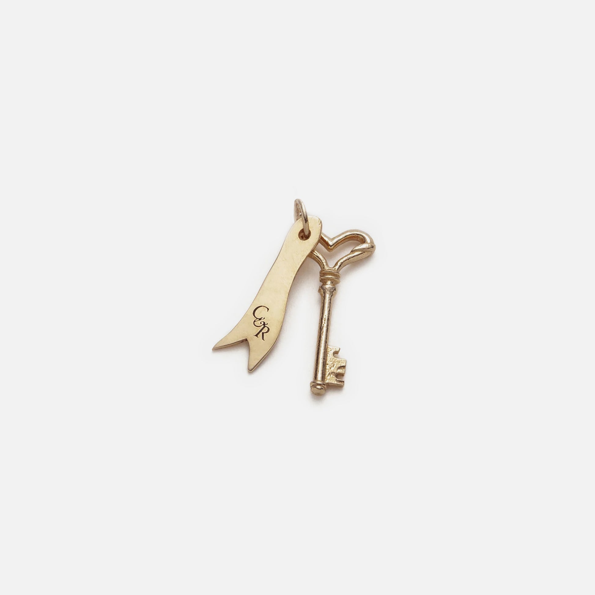 The Customizable You and I Necklace features a 14k yellow gold key and ribbon-shaped charm with CR initials on a small loop, offering elegant personalized initial jewelry displayed on a white background.