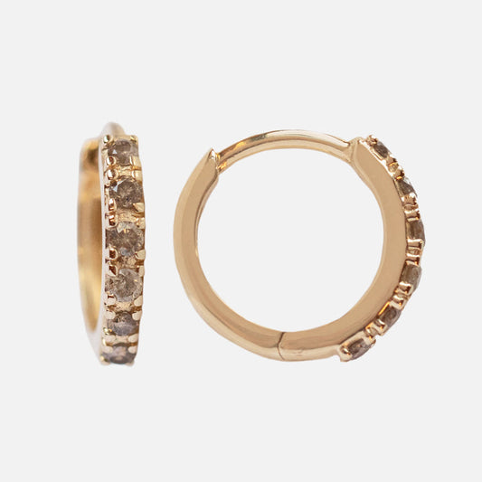 Solid Gold Salt and Pepper Diamond Huggie Hoops Sample: a pair of 10k yellow gold hoops featuring a row of sparkling salt and pepper diamonds along the front, shown on a plain white background.