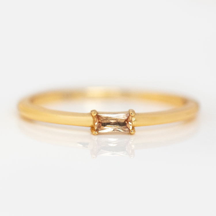 The Baguette Stacking Ring Sundazed Stone Sample Size 8 is a delicate gold ring with a rectangular, light brown gemstone set horizontally in a minimalist prong setting, shown on a white background.