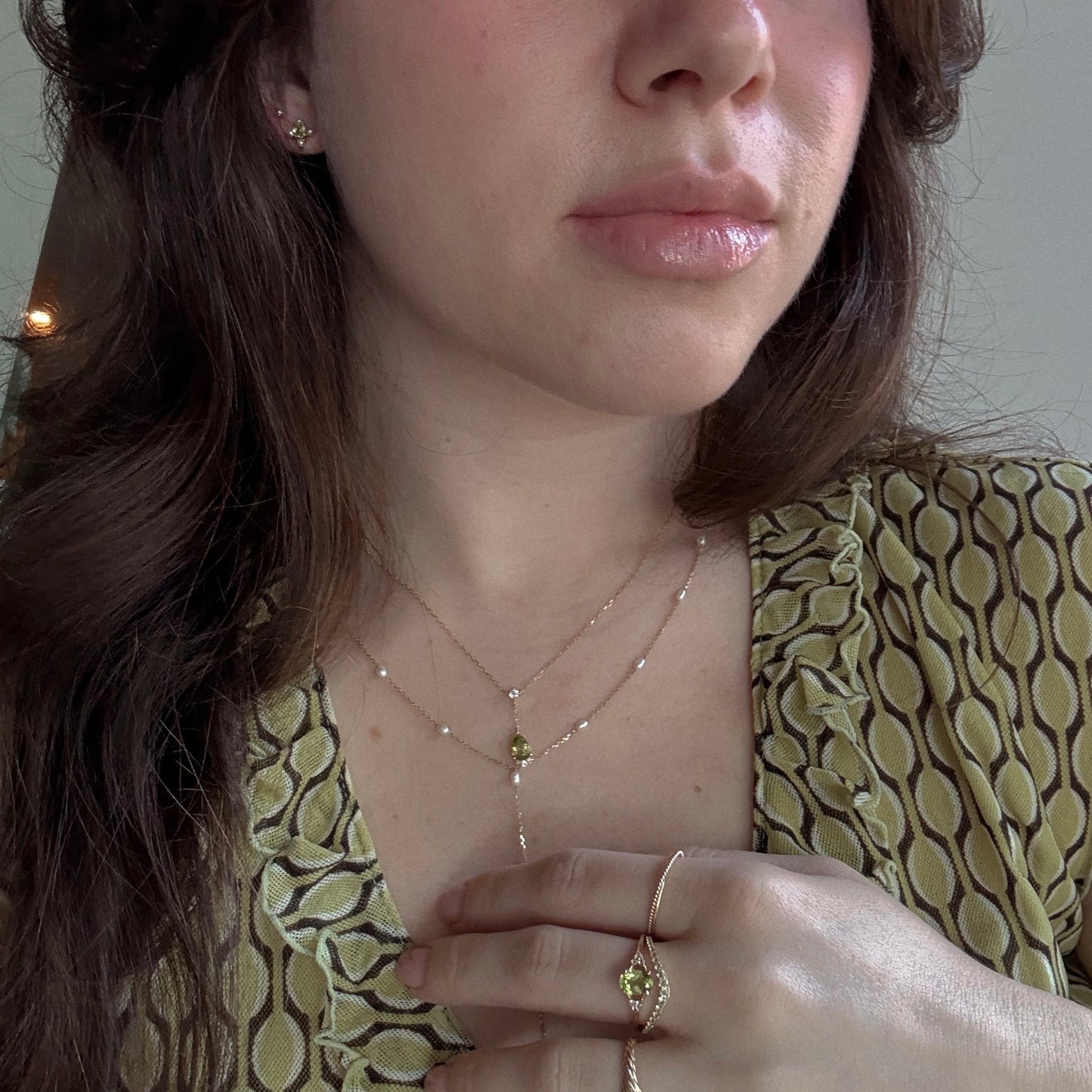 Peridot rings, necklace, and earrings worn styled with other jewelry