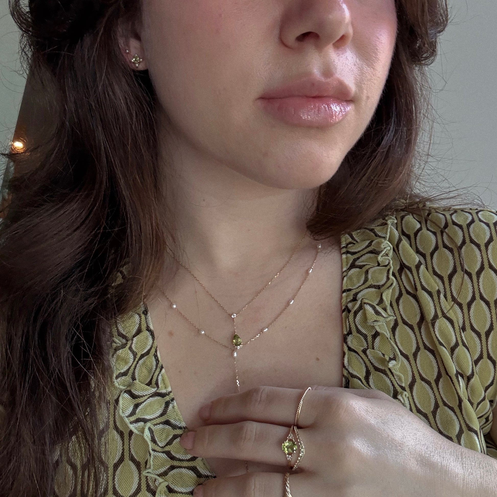 Peridot rings, necklace, and earrings worn styled with other jewelry