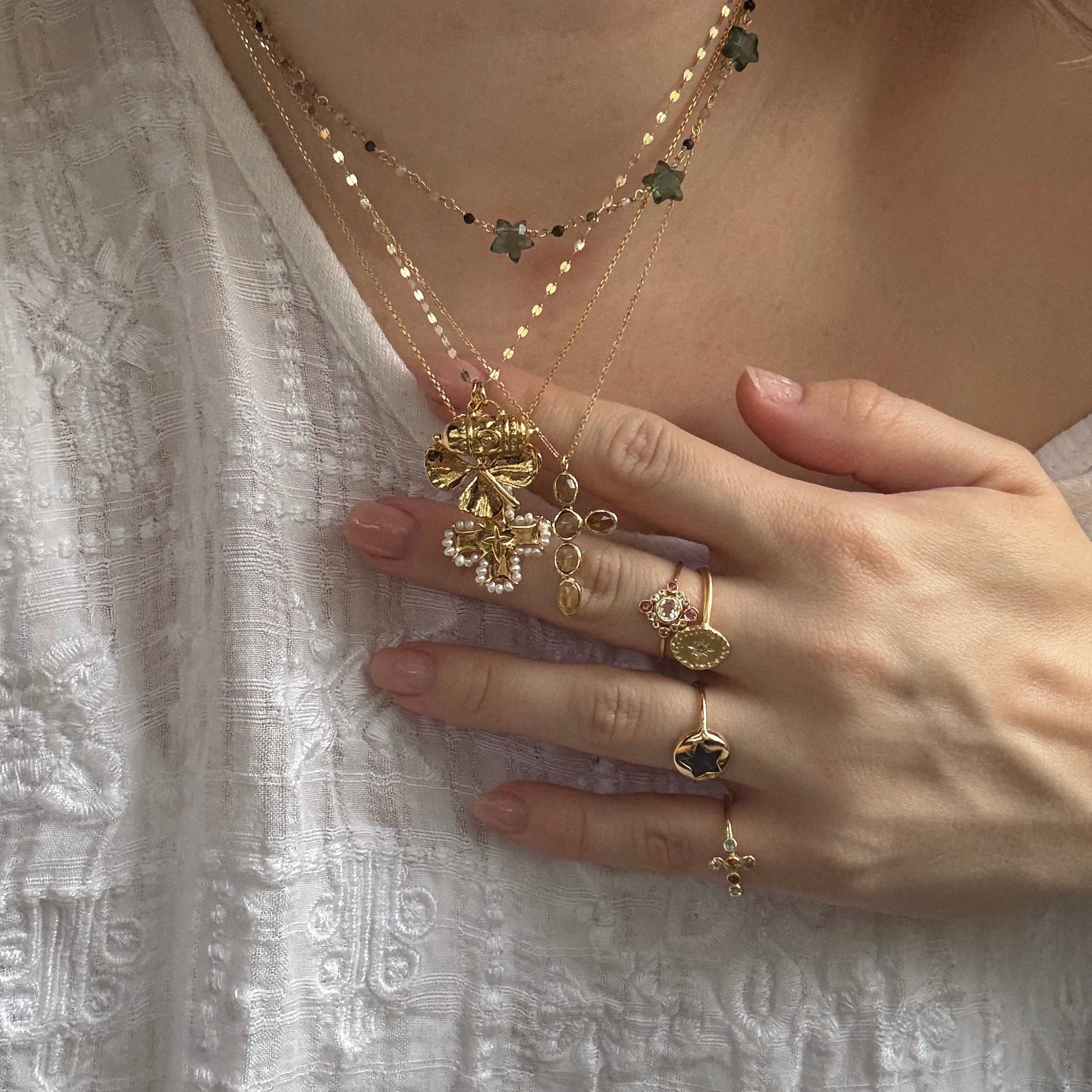 Tum and four leaf clover charm worn in a necklace stack