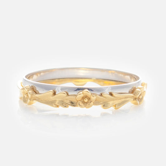 The Solid Gold Mixed Metal Filigree Band features a silver band with an intricate gold floral design of small flowers and leaves in a vintage-inspired style.
