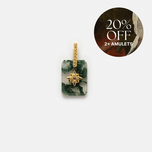 A rectangular green and white Solid Gold Crystal Amulet Charm for Manifestation features a gold star, beaded loop, and a “20% OFF 2+ AMULETS” circular label in the top right on a dark background with artwork.