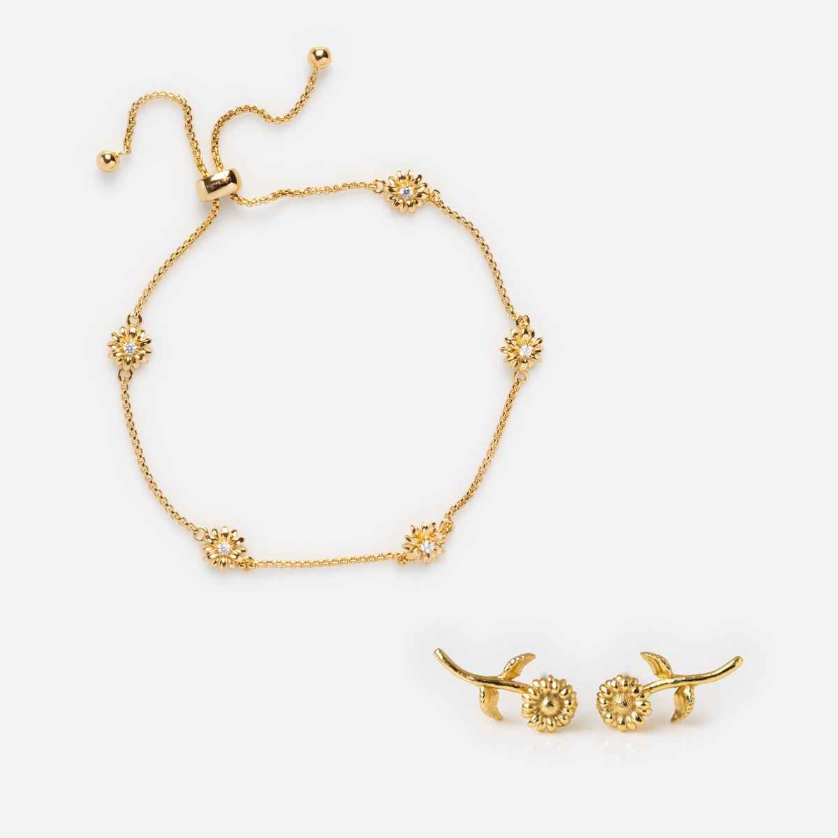 The Birth Flower Gift Set features a gold adjustable bracelet with flower-shaped charms and matching gold birth flower earrings, displayed on a white background.