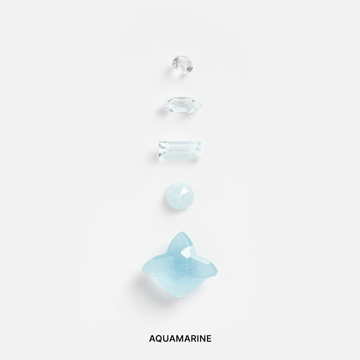Five aquamarine gemstones of different shapes and sizes are arranged vertically on a white background, evoking the calming energy of manifestation, with "Customizable Slim Signet Ring for Manifestation" written below.