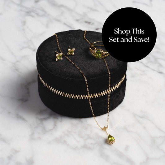 Peridot rings, necklace, and earrings on top of jewelry box