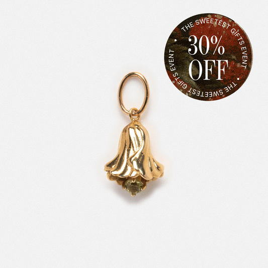 A 9k solid gold Birth Flower Bud Charm pendant with a small green gemstone is shown beside a round sticker stating "THE SWEETEST GIFTS EVENT 30% OFF.