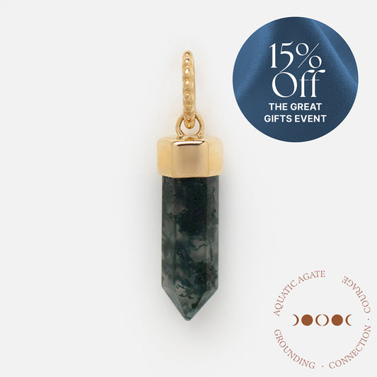 A Solid Gold Crystal Charm for Manifestation with natural moss agate hangs on a beaded loop. Enjoy 15% Off The Great Gifts Event. A gold moon phase symbol highlights Aquatic Agate: Grounding, Connection, Growth.