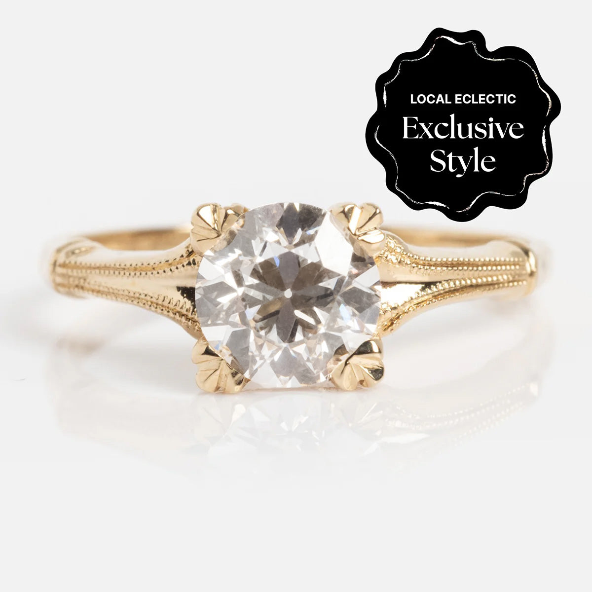 The 14k Elara Ring is a gold ring with intricate detailing, featuring a 1.05 ctw round diamond center and a sleek 1.4 mm band. A black badge in the top right corner reads "Local Eclectic Exclusive Style" in white text.