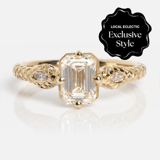 The 14k Enchantress Ring features an emerald-cut lab diamond center and two marquise-cut stones on a textured gold band. A black badge reads "Local Eclectic Exclusive Style" in white text.