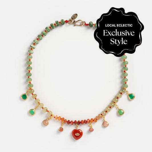 The Golden Hour Necklace features green, orange, and gold beads, gold trim, dangling charms, and a central red heart charm. A black label in the corner reads Local Eclectic Exclusive Style.