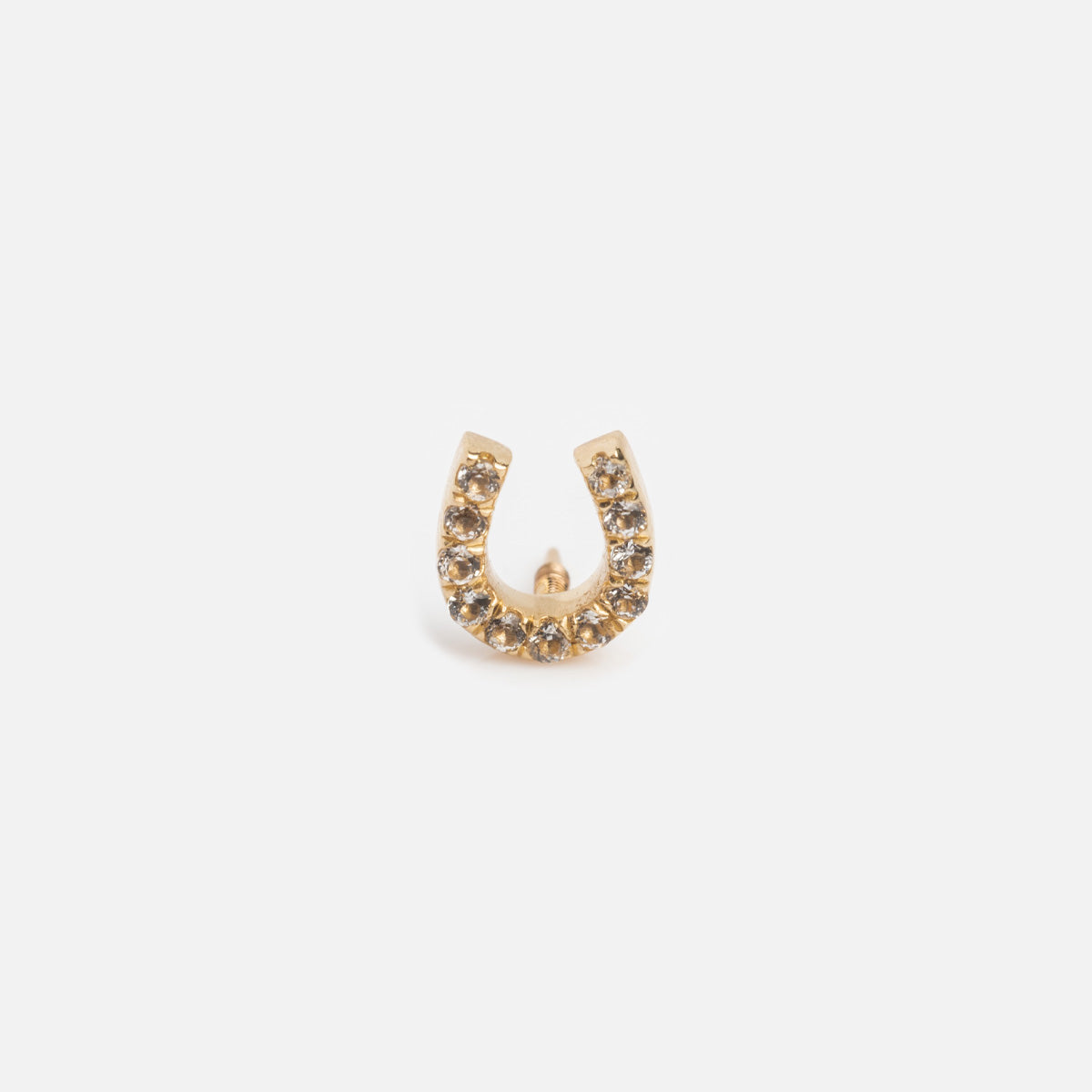 The Solid Gold Horseshoe Flat Back Studs are small, horseshoe-shaped gold earrings accented with clear rhinestones and showcased against a plain white background.