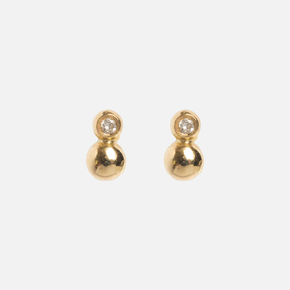 The Solid Gold Diamond Dawn Ball Studs are delicate earrings in solid gold, each with a round gold bead beneath a sparkling diamond, displayed on a plain white background.