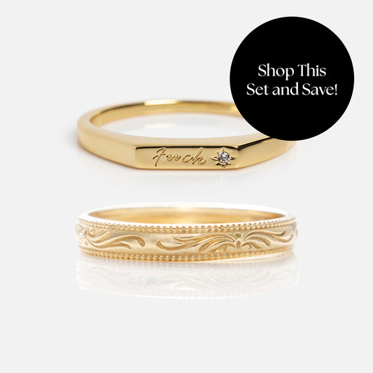 The Solid Gold Tiny Fuck Filigree Stacking Ring Set features two gold rings on a white background: one engraved with “f*ck” and a tiny diamond, the other with an ornate floral design. A black circle overlay reads, Shop This Set and Save!.