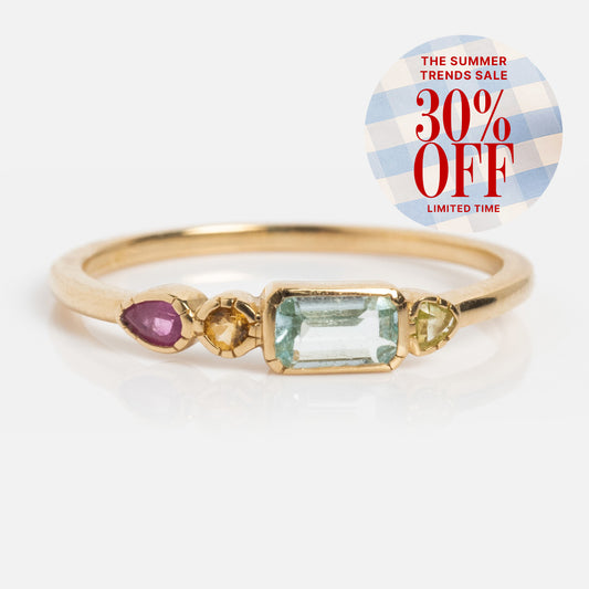 The Solid Gold First Light Pastel Gemstone Ring features three vibrant pastel stones, with a “The Summer Trends Sale 30% Off Limited Time” sticker in the top right corner on a white background.