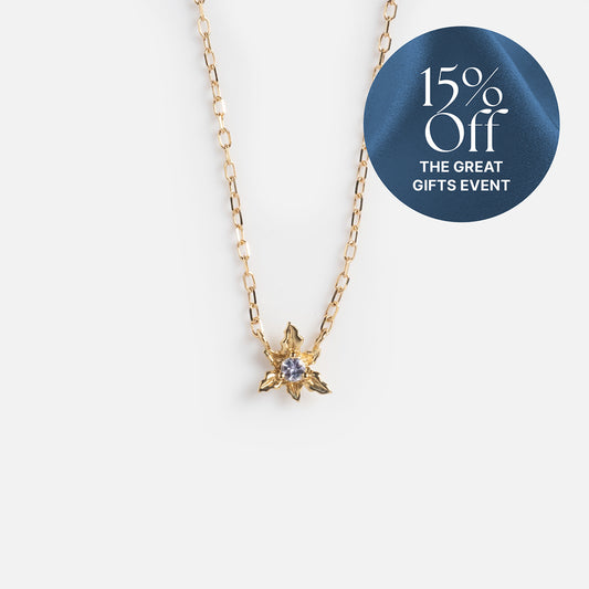 The Solid Gold Birth Flower Bloom Necklace features a delicate star-shaped pendant with a central gemstone, set against a white background. A blue label in the corner announces 15% Off THE GREAT GIFTS EVENT.