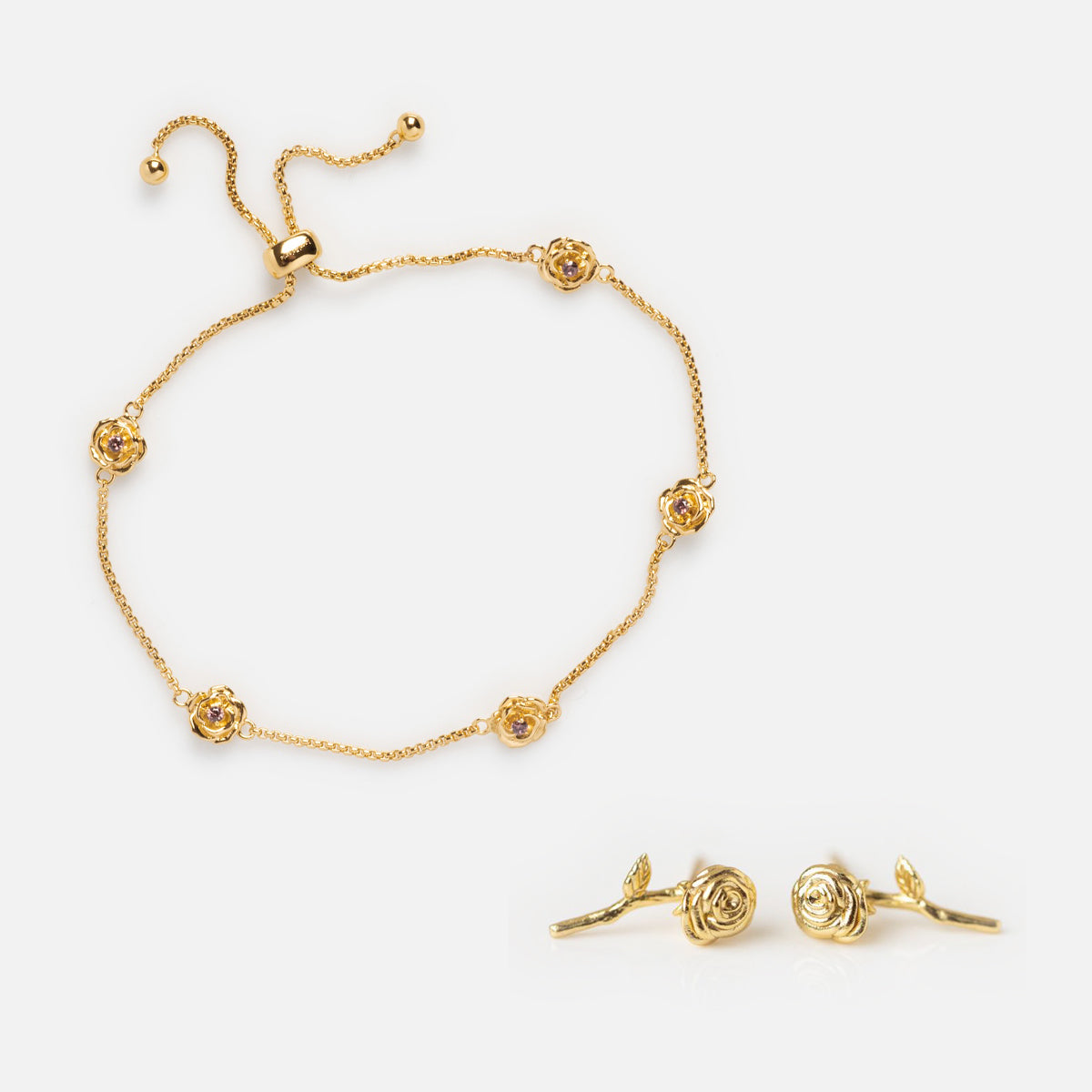 The Birth Flower Gift Set features a delicate gold bracelet with adjustable clasp and rose-shaped charms, plus matching earrings, all beautifully displayed on a white background.
