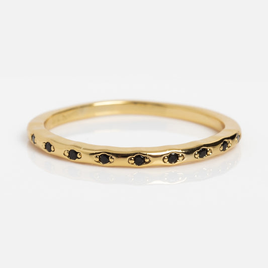 The Regency Stacking Ring is a thin yellow gold plated band with small, evenly spaced black stones set around it, shown on a white background.