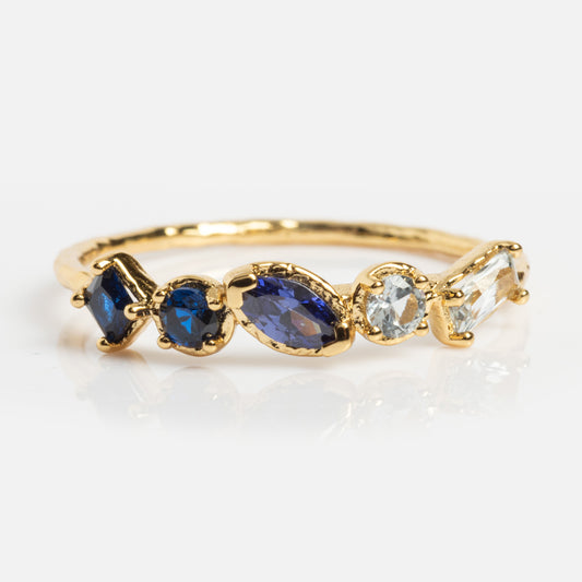 The Shades of You Ombre Birthstone Ring is a 14k gold plated piece featuring five blue and clear gemstones in different shapes and sizes, aligned along the band—ideal as stylish birthstone jewelry.