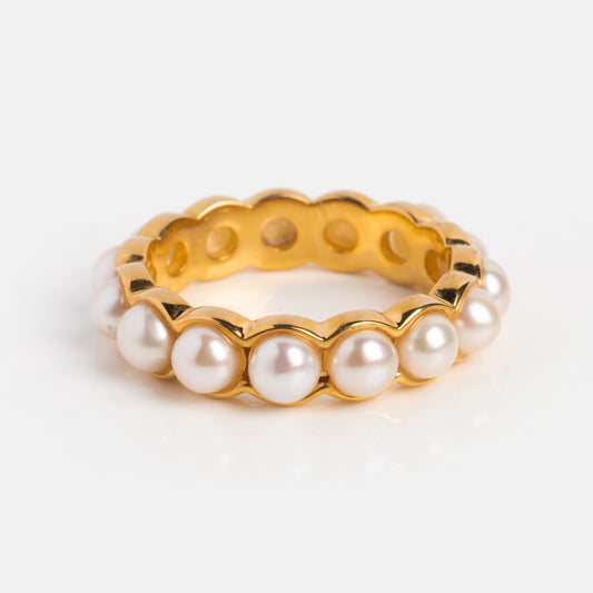 The Bold Pearl Band is a 14k yellow gold plated ring with a wavy band design, featuring evenly spaced white pearls around its circumference, shown on a white background.